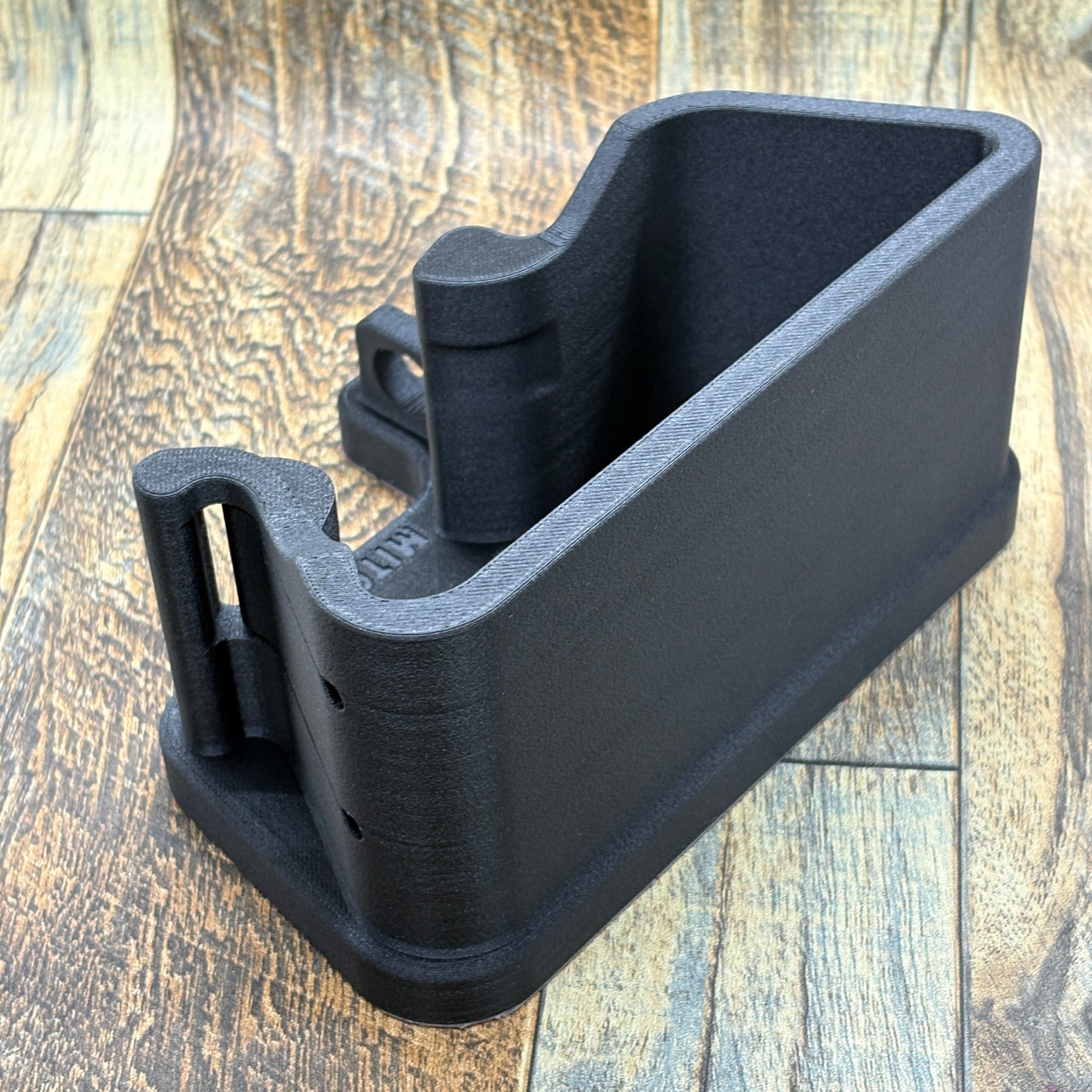 Black plastic component on a wooden surface